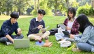 195461112-happy-young-asian-college-students-relaxing-in-the-campus-s-park-discussing-and-working-their-group.jpg